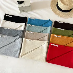 Detailed view of colorful knitted triangle scarves, wool blend texture, neat display closeup.