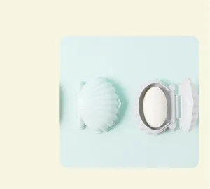 Vue détaillée du porte-savon coquillage portable avec couvercle, montrant le double drainage.