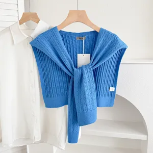 Blue cable knit sweater shawl paired with white shirt, stylish layered women autumn outerwear.