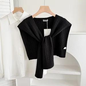 Women's knit shawl layered with white shirt, stylish autumn outerwear and versatile clothing.