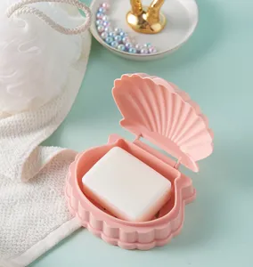 Vue detaillee du porte-savon rose en forme de coquillage avec grille et savon blanc propre.