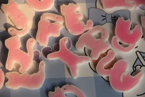Primo piano di simpatici ciondoli in resina di gatto rosa in varie pose giocose.