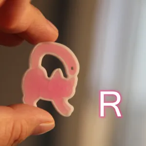 Primo piano dettagliato di un simpatico ciondolo in resina gatto rosa per creazioni.