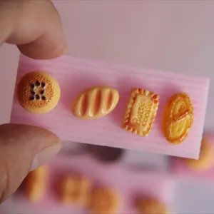 Set de moldes de resina de comida en miniatura con bandeja ondulada y dijes de pan y galletas.