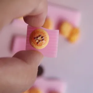 Detalle de molde de silicona en miniatura con diseño de bandeja ondulada y comida.