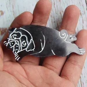 Detailed view of a cute sleeping pug shaped resin accessory, showing fine workmanship and shape.