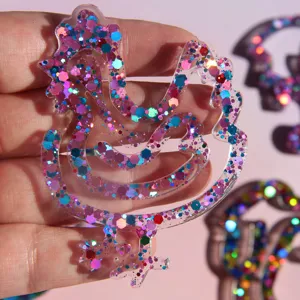 Close-up detail of the transparent glitter resin rooster craft bookmark with colorful flakes.
