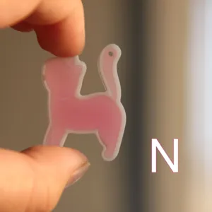 Primo piano dettagliato del ciondolo gatto rosa con struttura in resina semitrasparente.
