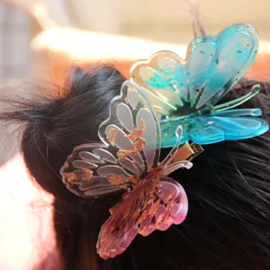 Butterfly hair clip detail showcasing resin material and shimmering gold foil accents for hairstyles.