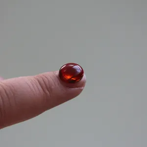 Runder roter Edelstein-Cabochon auf Finger, kleine Handwerks-Harzform-Musterperle.