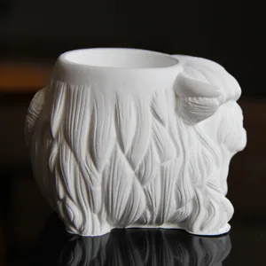 Detailed close-up of a white highland cow shaped plaster pen holder, candle cup or container.