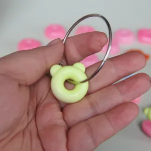 Close-up detail shot of a cute bear donut pendant charm with metal ring, perfect craft display.