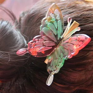 Detailed close-up of a colorful resin 3d butterfly hair clip worn in hair, elegant.