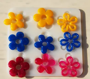 Colorful resin flower charms and silicone mold set for handmade DIY jewelry crafting.