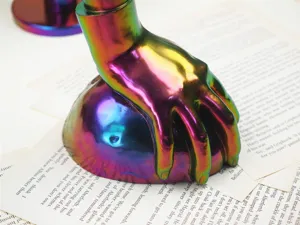 Detailaufnahme der schimmernden Hand-Skulptur mit glänzender und glatter metallischer Oberfläche.