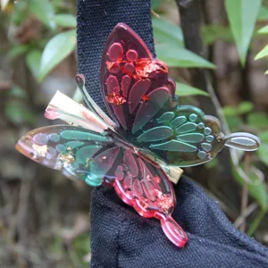 Detailed view of a colorful resin butterfly hair clip with gold foil flakes, stylish hair accessory.