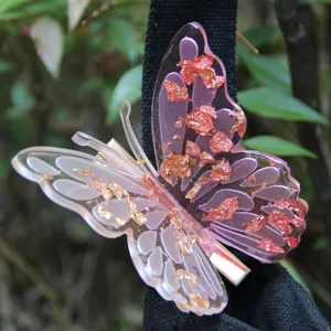 Detailed close-up of a stunning pink resin butterfly hair clip decorated with sparkling foil.