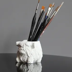 Highland cow pen holder detail, white plaster animal desk organizer with paintbrushes inserted.