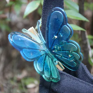 Beautiful blue resin butterfly hair clip with sparkly glitter details for daily styling.