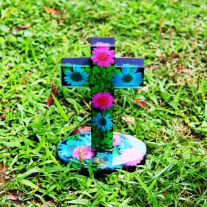 Ornement de croix en fleur séchée en résine avec base ronde, idéal pour décor et cadeau.
