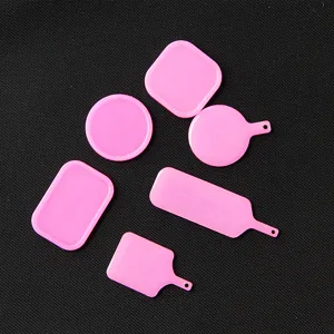 Detailaufnahme kleiner pinker Harztablett-Formen in verschiedenen runden und eckigen Formen.