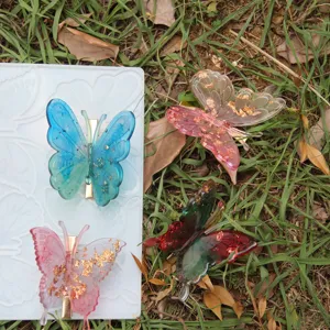 DIY 3D butterfly silicone mold and resin hair clip set with gold foil sparkle details.