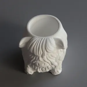 Closeup of cute highland yak animal shaped white plaster pen holder and candle cup container.