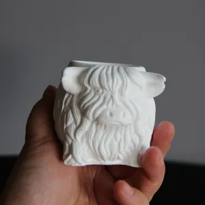 Highland cow cup detail view, white gypsum pen holder and candle jar mold showcasing texture.