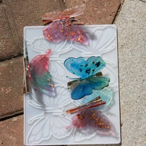 Butterfly resin mold and finished hair clips set for DIY craft accessories detail.