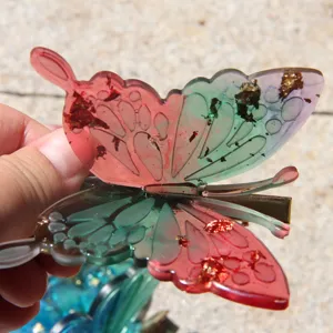 Colorful resin butterfly hair clip with gold foil flakes, handmade style fashion hair accessory.