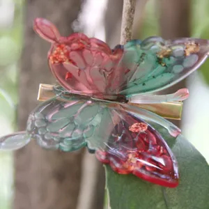 Beautiful resin butterfly hair clip with pink and green gradient and gold foil details.