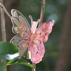 Close-up detail of a pink butterfly hair clip featuring translucent resin and shiny gold foil accents.