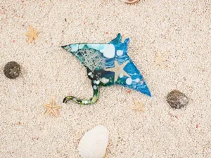 Resin stingray marine animal pendant detail view with embedded coral and starfish elements.