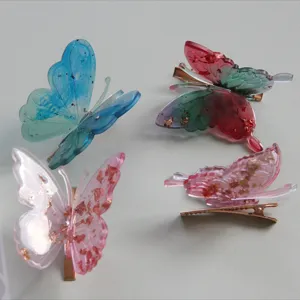 Translucent resin butterfly hair clips with gold flakes and metal alligator clips.
