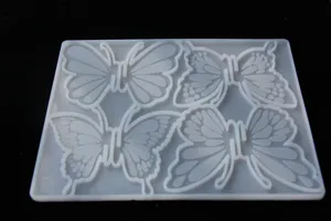 Detailed view of the 4-cavity butterfly silicone mold for DIY hair clip resin casting crafts.