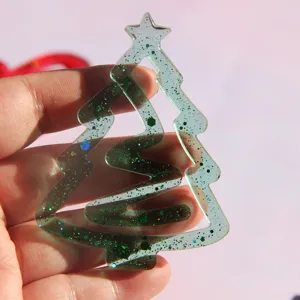 Nahaufnahme Detail eines transparenten Harz Weihnachtsbaum Lesezeichens mit grünem Glitzer.