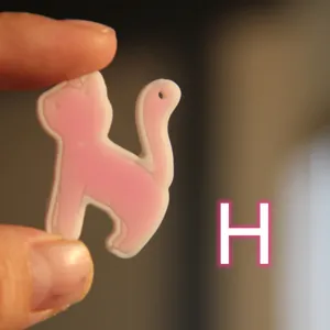 Dettaglio ciondolo gatto rosa carino, accessorio stampo resina, bel design di gattino.
