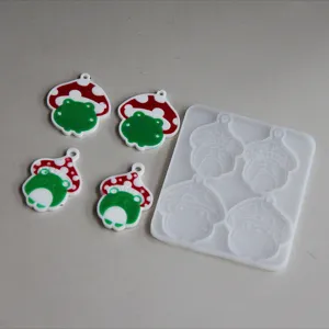 Detailansicht von süßen Pilz Frosch Anhänger Silikonform und fertigen Epoxidharz Charms.