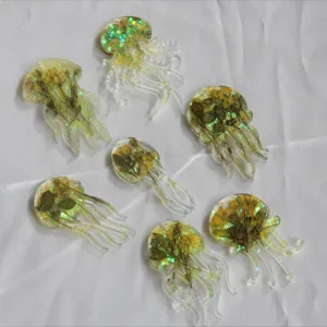 Detailaufnahme von Harz-Qualle Anhänger mit getrockneten Blumen und Glitzer innen, Handarbeit.