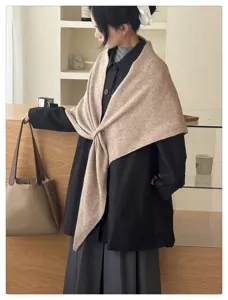 Detail shot of cozy wool triangle scarf worn by model indoors, elegant winter accessory.