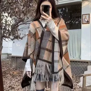 Women autumn plaid tassel shawl cape, elegant knitted outerwear, stylish cozy fashion.