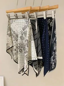 Detailed view of stylish vintage printed silk scarves hanging neatly on wooden hangers.
