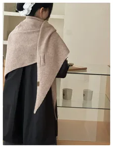 Cozy knitted triangle scarf detail, soft wool blend winter shawl worn in indoor setting.