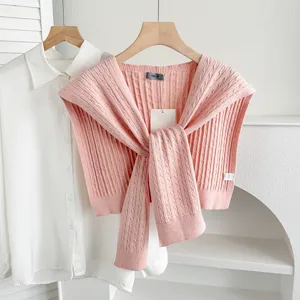 Pink knit shawl detail shot, stylish twisted cable knit scarf layered with white shirt for women.