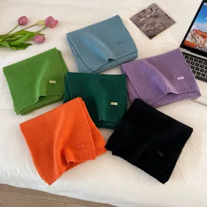 Detailed view of colorful knitted winter scarves set, neatly folded flat lay showcase.