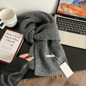 Vista detallada de la bufanda de invierno de punto gris oscuro con una textura muy suave.