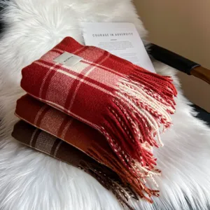 Detail shot of cozy winter plaid scarf with fringe, featuring soft warm texture and stylish colors.