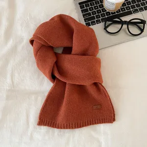Caramel brown knitted scarf detail view, cozy winter texture and elegant flat lay styling.