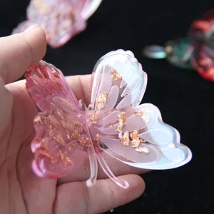 Detailed view of handmade epoxy resin butterfly with gold foil accent for DIY crafts decoration.