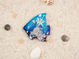 Detailed view of blue purple gradient fish resin craft with embedded starfish and coral decor.